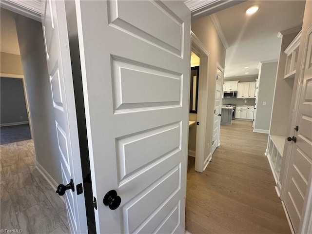 hall with recessed lighting, light wood-style floors, baseboards, and ornamental molding