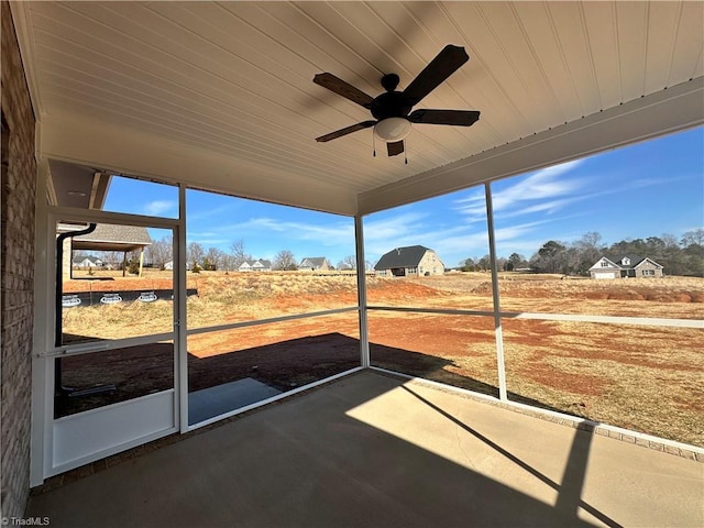 unfurnished sunroom featuring ceiling fan