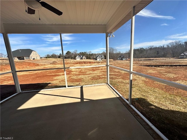 unfurnished sunroom with a ceiling fan