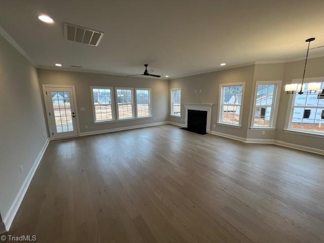 unfurnished living room with crown molding, dark hardwood / wood-style flooring, and ceiling fan with notable chandelier