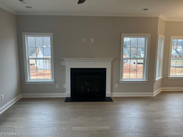 unfurnished living room with wood-type flooring, ornamental molding, and ceiling fan