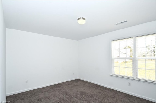 empty room featuring dark colored carpet