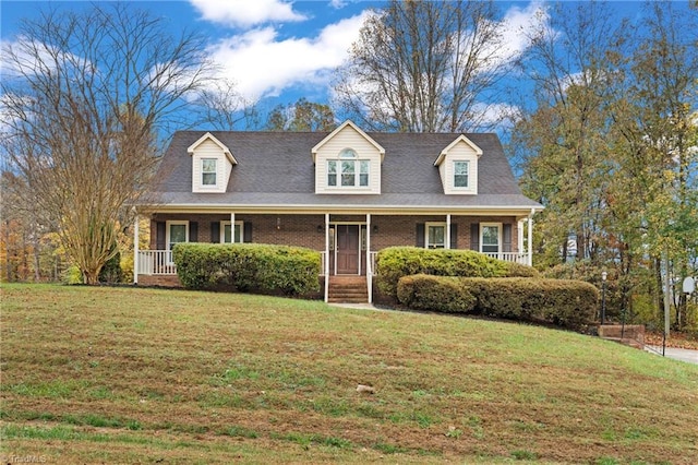 new england style home featuring covered porch and a front lawn