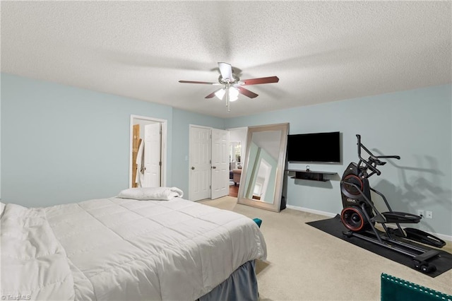 bedroom featuring a textured ceiling, light colored carpet, and ceiling fan