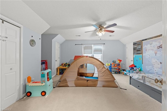 rec room with carpet flooring, a textured ceiling, lofted ceiling, and ceiling fan