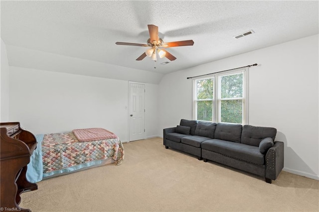 carpeted bedroom with ceiling fan and a textured ceiling