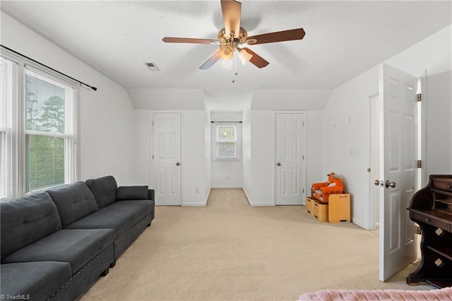 carpeted living room featuring ceiling fan and vaulted ceiling