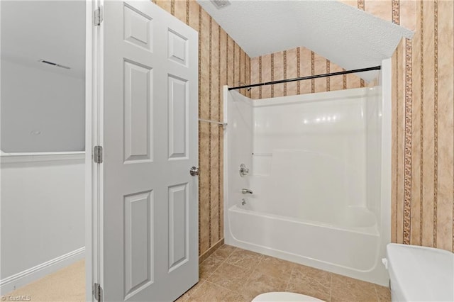 bathroom featuring tile patterned flooring, toilet, and  shower combination