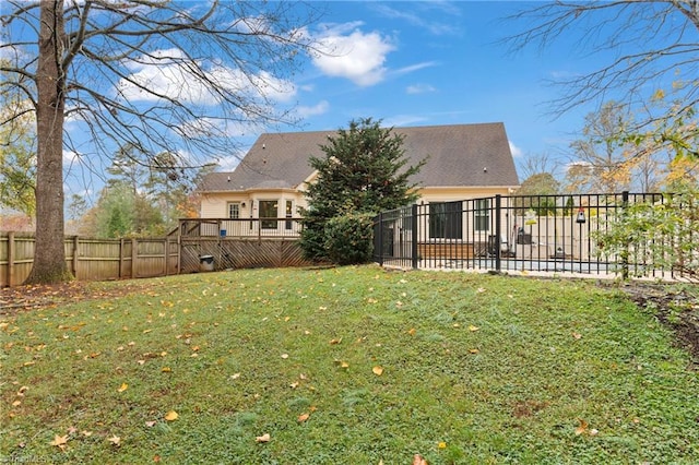 back of property with a wooden deck and a yard