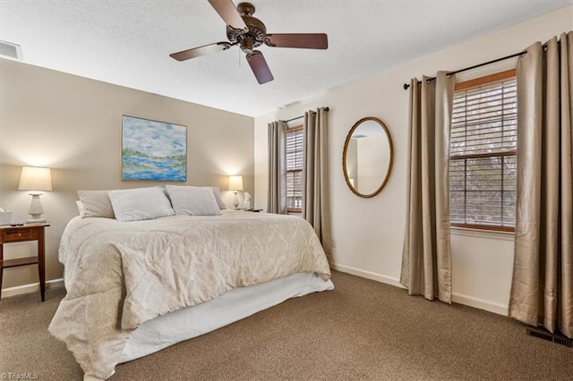 bedroom featuring multiple windows, baseboards, carpet floors, and a textured ceiling