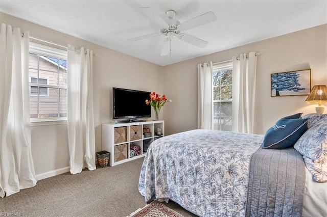 carpeted bedroom featuring baseboards and ceiling fan