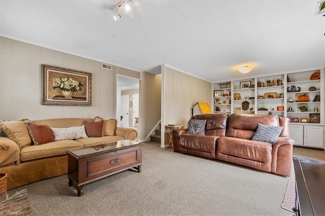 carpeted living area with visible vents, ornamental molding, and stairs