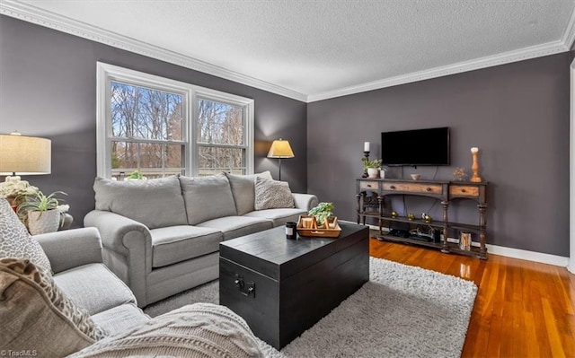 living room featuring a textured ceiling, crown molding, baseboards, and wood finished floors