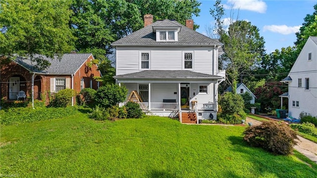 rear view of property featuring a porch and a lawn