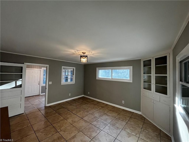 spare room with tile patterned floors and crown molding