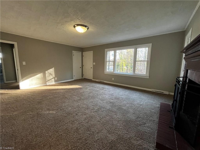 unfurnished living room featuring dark colored carpet, a textured ceiling, a brick fireplace, and ornamental molding