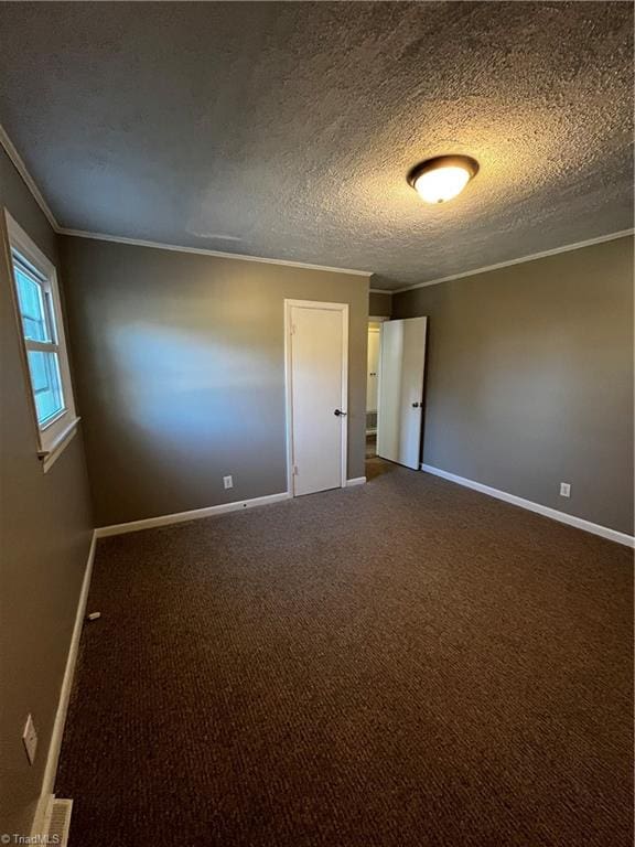 carpeted empty room with a textured ceiling and crown molding