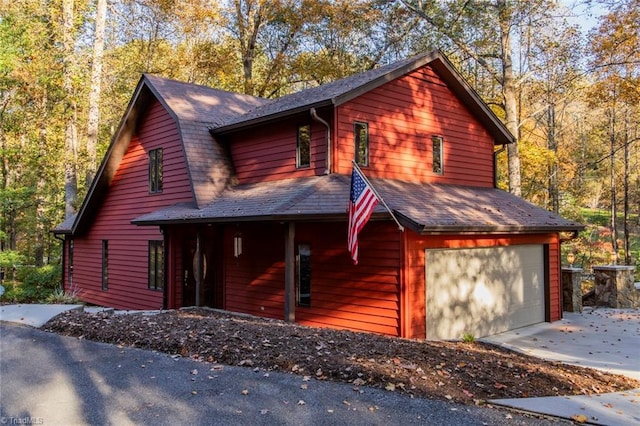 chalet / cabin with driveway and a garage