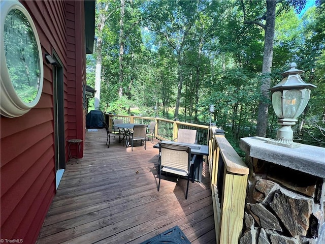 wooden terrace featuring grilling area and outdoor dining area