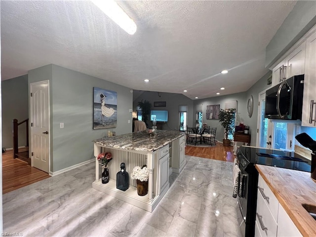 kitchen with butcher block counters, a textured ceiling, baseboards, and black electric range oven