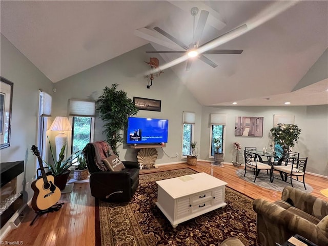 living room featuring high vaulted ceiling, ceiling fan, a wealth of natural light, and wood finished floors