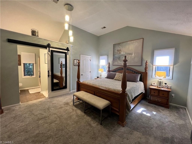 carpeted bedroom with a barn door, connected bathroom, baseboards, lofted ceiling, and visible vents