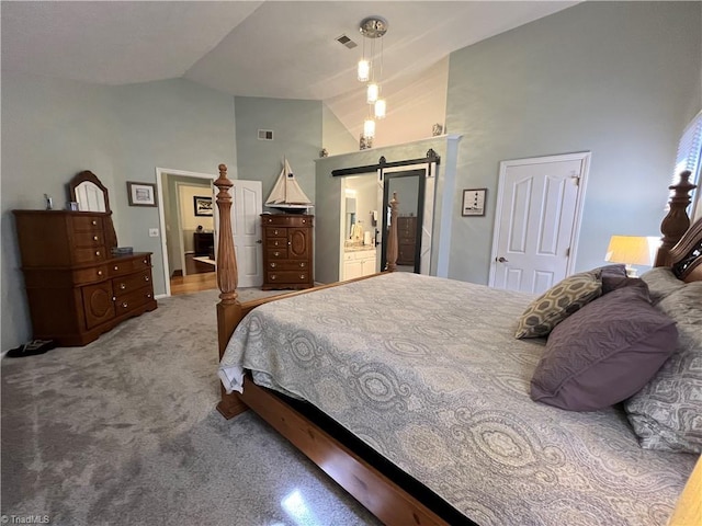 carpeted bedroom featuring high vaulted ceiling, a barn door, connected bathroom, and visible vents