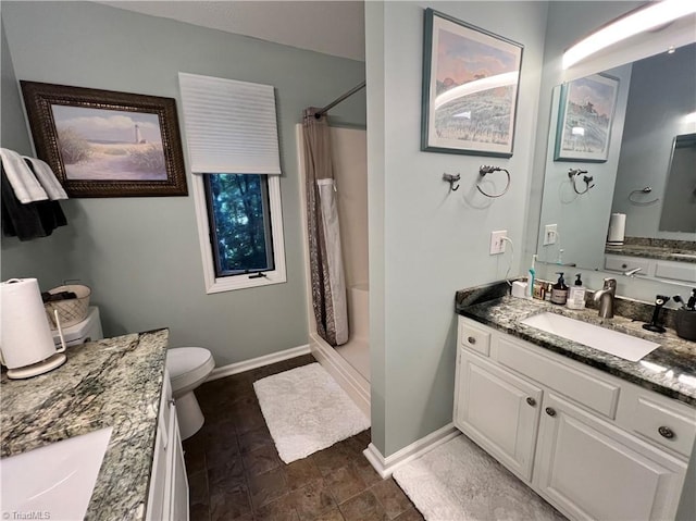 bathroom with toilet, vanity, stone finish flooring, baseboards, and a shower with shower curtain