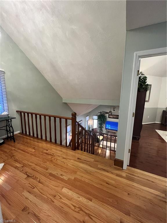 bonus room with lofted ceiling, wood finished floors, and baseboards