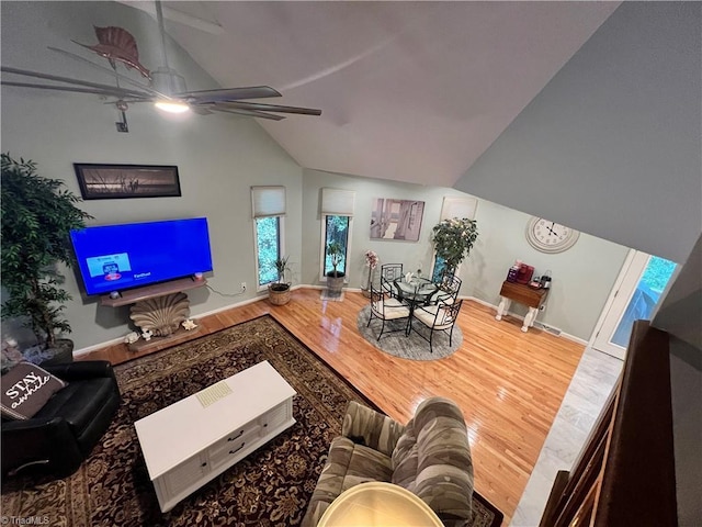 living area with vaulted ceiling, wood finished floors, a ceiling fan, and baseboards