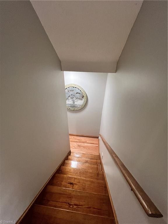 stairs featuring wood finished floors