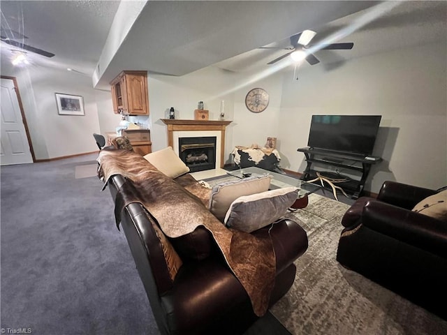 carpeted living area with ceiling fan, baseboards, and a fireplace