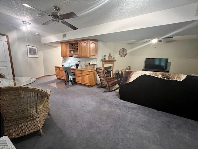 carpeted bedroom with baseboards, a textured ceiling, visible vents, and a fireplace