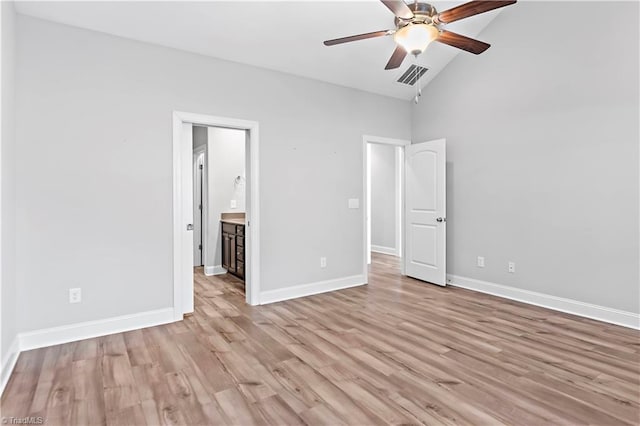 unfurnished bedroom with ceiling fan, light hardwood / wood-style floors, connected bathroom, and lofted ceiling