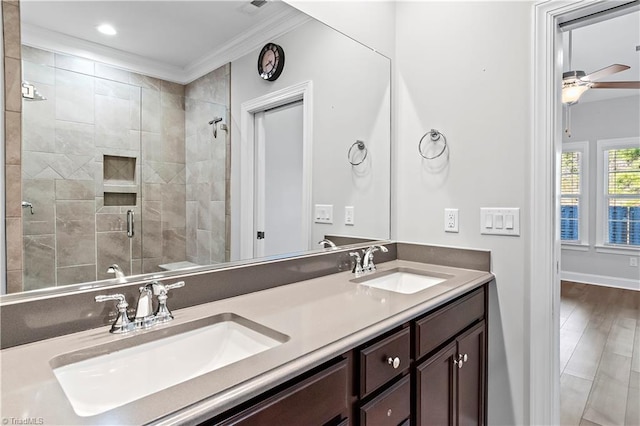 bathroom with ceiling fan, vanity, crown molding, hardwood / wood-style flooring, and a shower with door