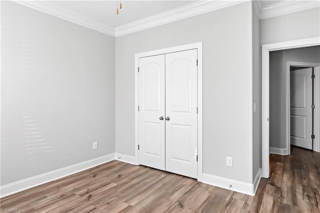 unfurnished bedroom featuring hardwood / wood-style floors and crown molding