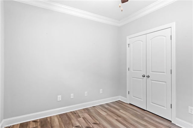 unfurnished bedroom featuring a closet, ornamental molding, and light hardwood / wood-style flooring