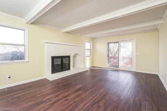 unfurnished living room featuring crown molding, a brick fireplace, dark wood-type flooring, and a wealth of natural light