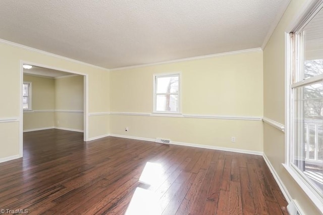 spare room featuring dark wood-type flooring, ornamental molding, and a textured ceiling