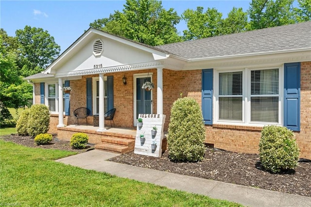 5215 Hicone Rd, Mcleansville, NC 27301 - view of front of home featuring covered porch, brick siding, a shingled roof, and a front yard