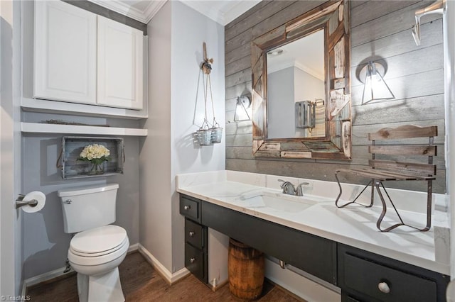 5215 Hicone Rd, Mcleansville, NC 27301 - bathroom featuring ornamental molding, toilet, vanity, wood walls, and baseboards