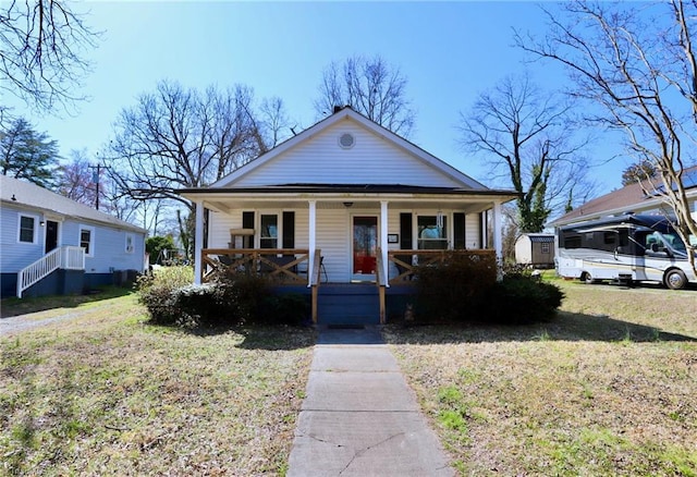 bungalow with a front lawn and covered porch