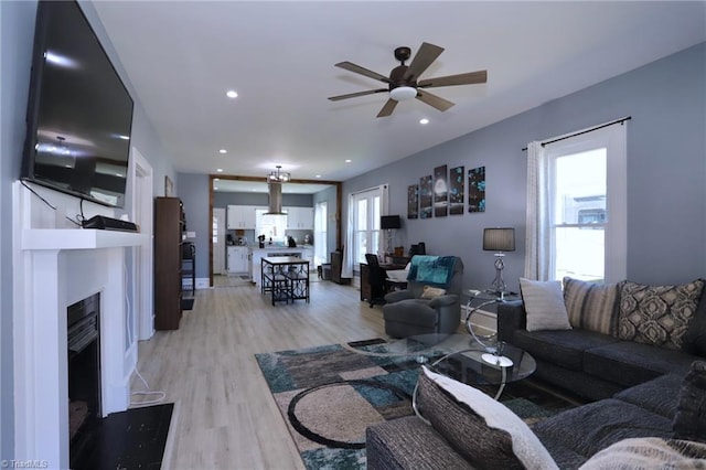 living room with a fireplace, recessed lighting, light wood-type flooring, and ceiling fan