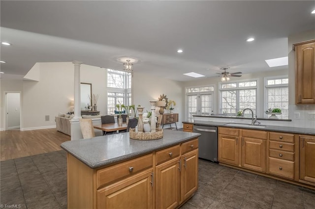 kitchen featuring a center island, ceiling fan, stainless steel dishwasher, dark hardwood / wood-style floors, and sink