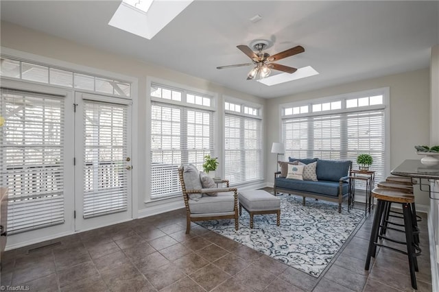 sunroom featuring ceiling fan and a skylight