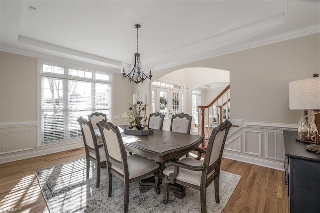 8602 Yvonne Ct, Oak Ridge, NC 27310 - dining space with a tray ceiling, a decorative wall, arched walkways, and a notable chandelier