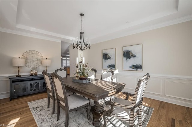 8602 Yvonne Ct, Oak Ridge, NC 27310 - dining space featuring a wainscoted wall, wood finished floors, ornamental molding, a chandelier, and a tray ceiling