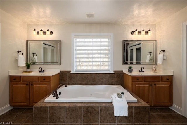 bathroom with tiled bath, vanity, and tile patterned floors