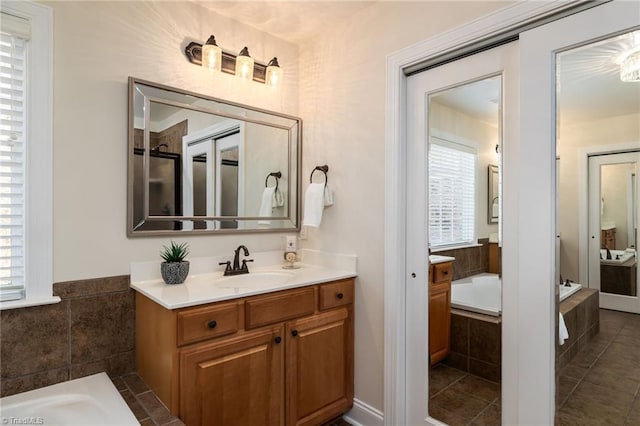 bathroom with vanity and a relaxing tiled tub