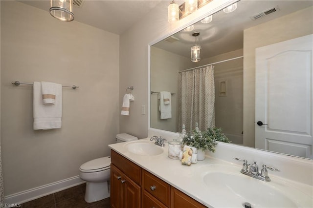 bathroom featuring tile patterned flooring, curtained shower, vanity, and toilet